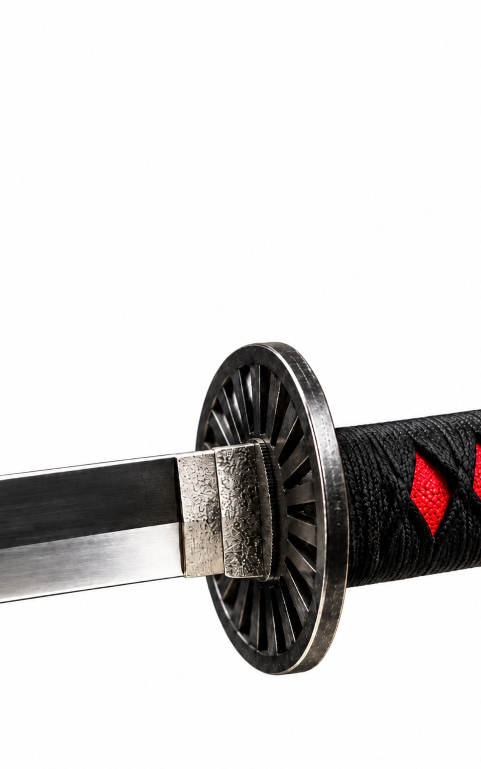 Close-up of a black sword guard and black handle with red accents on a white background